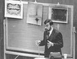 Dr. Lowell J. Levine, a New York forensic ondontologist, testifies that the bite marks found on the but�tocks of a Florida State University coed reflect characteristics of Ted Bundy's teeth. Photos of Bundy's teeth and bite markes are displayed on the chalk board behind Dr. Levine during the 1979 trial in Tallahassee, Florida.